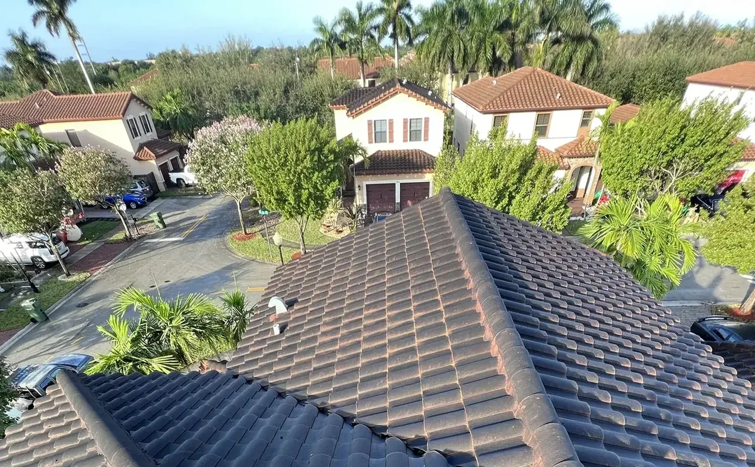 A South Florida barrel-tile roof half cleaned by Florida Hydro Works — algae on one side, clean tile on the other